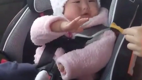 Hungry baby adorably struggles to reach snack