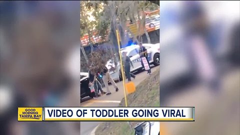 Video: Toddler walks with her hands up toward police officer