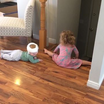A Tot Girl Watches Over Her Baby Brother