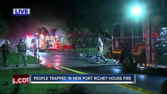 Crews battle fire with woman trapped inside