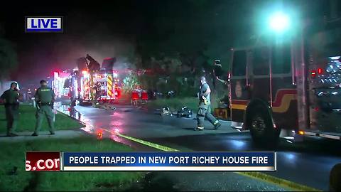 Crews battle fire with woman trapped inside