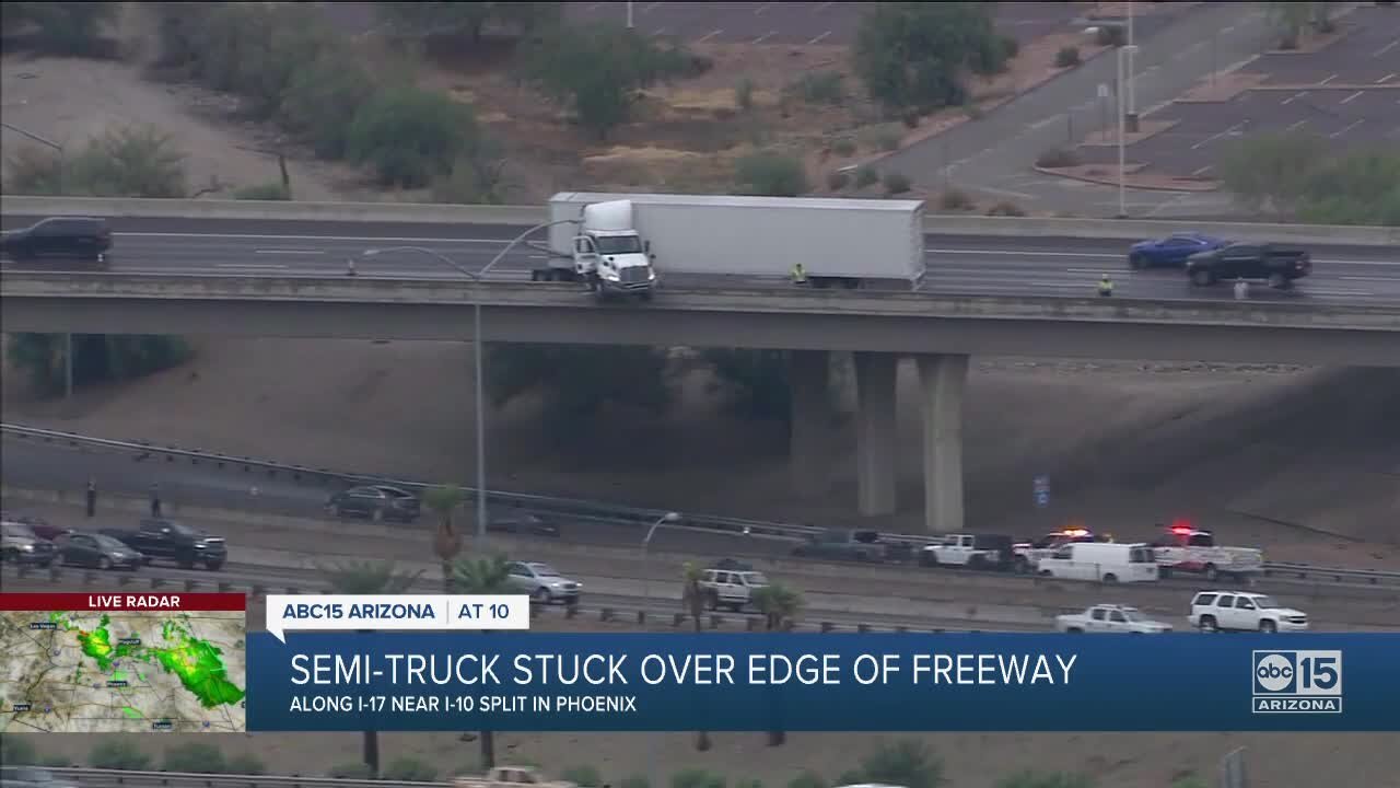 Semi-truck loses control, gets stuck on edge of freeway ramp