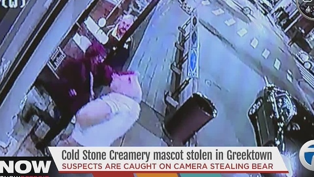Two people caught on camera taking a large teddy bear