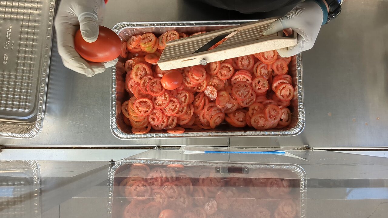 Slicing tomatoes with a mandolin for Celebrate Recovery®. They'll go on top of some burgers.