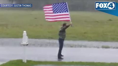 Guy with flag braves Hurricane Irma