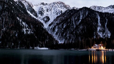 Rain mixed with snow at a mountain range by a lake