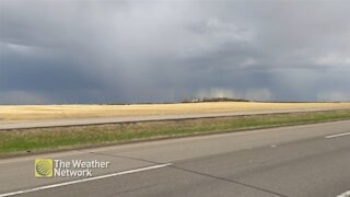 Curtains of rain sink over prairie fields