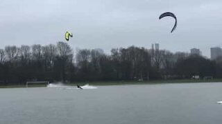 Kitesurfere morer seg på en oversvømmet fotballbane
