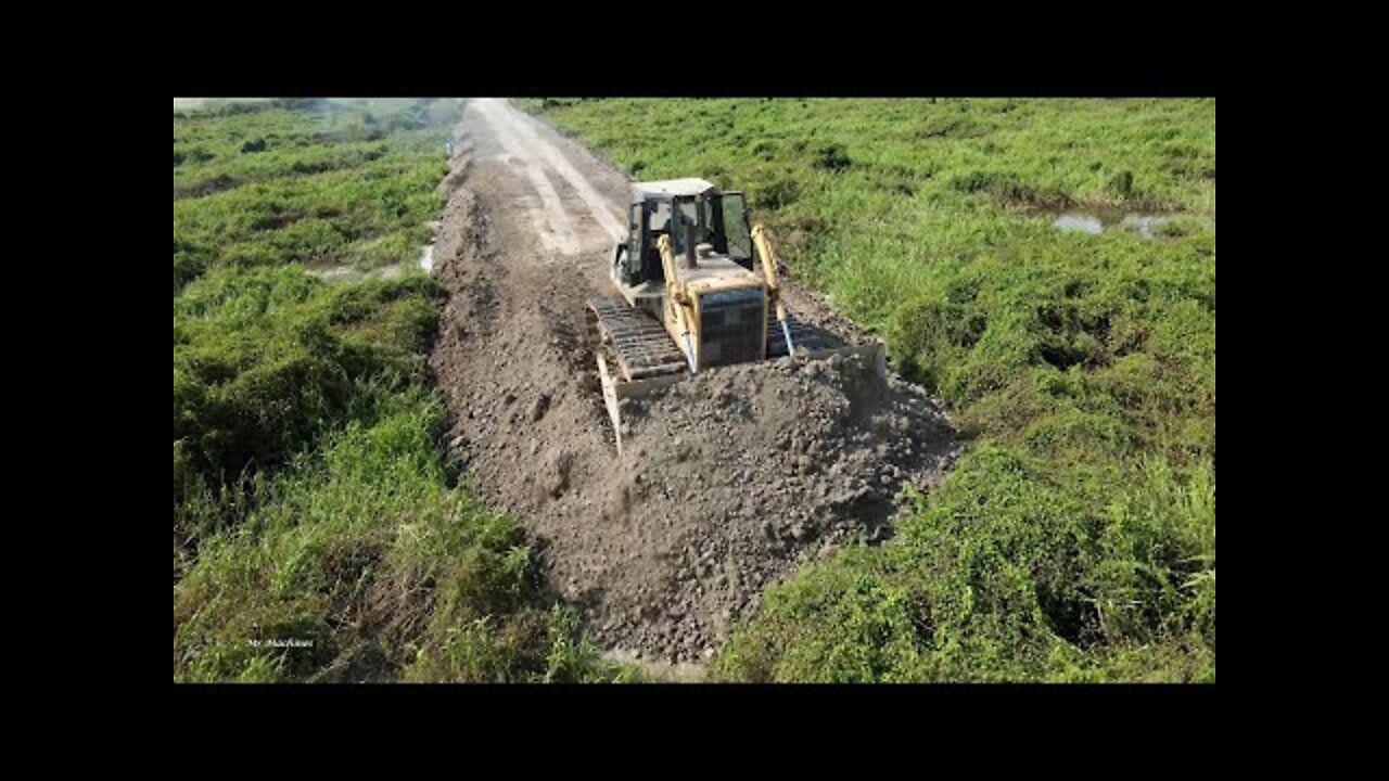 Awesome Mighty bulldozer and truck building new road across forestry swamp