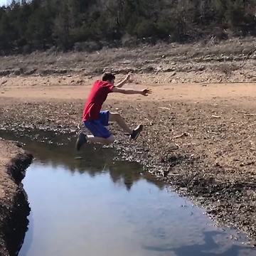 Boy Makes Huge Jump Across Stream, Lands in Mud and Loses Shoes