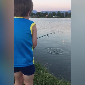 A Young Boy Gets Scared By A Fish When He Pulls It From The Water
