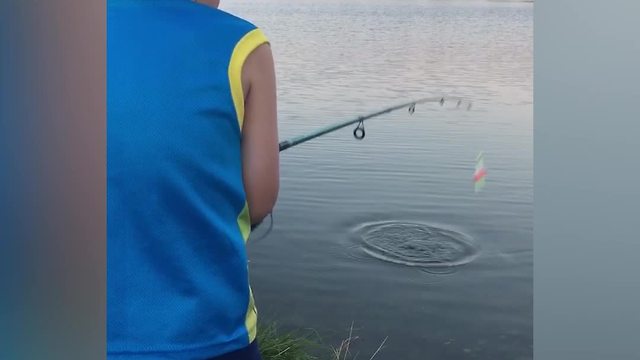 A Young Boy Gets Scared By A Fish When He Pulls It From The Water