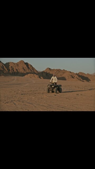A Man Driving a Quad Bike in the Desert