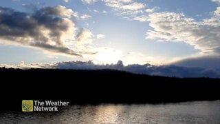 Dark and stormy clouds approach on a sunny day at the water