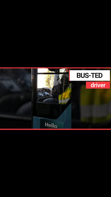 Bus driver reads newspaper behind the wheel during rush hour