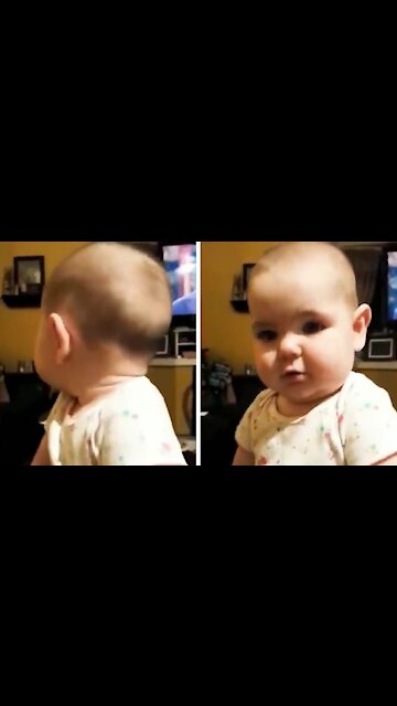 Baby looks at the camera and tries to reproduce what his mother says to him