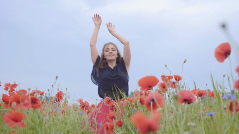 Girl dancing happily in a field of flowers.