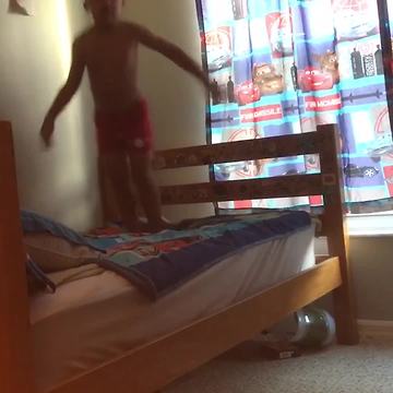 Happy Kid Jumps On Bed