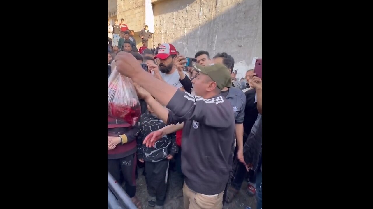 Palestinian Man Holds Up Bag of Body Parts Talking to the Rest of the World