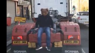 Un homme avec un masque d'ours grimpe sur un camion