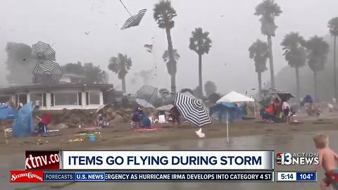 Umbrellas go flying during storm on California beach