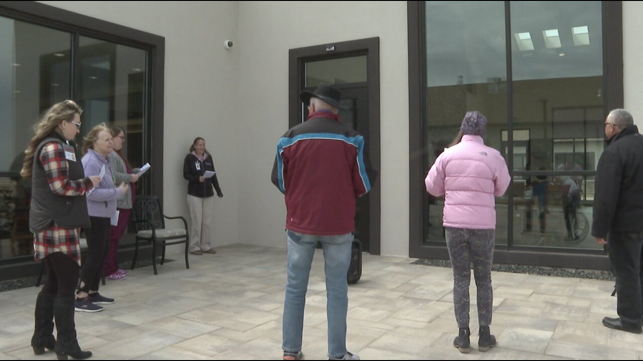 Volunteers singing outside assisted living facilities to bring residents cheer