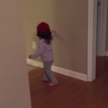 Tot Girl Puts A Beanie Over Her Head And Navigates Around A House