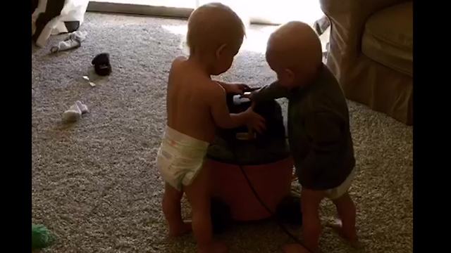 Tot Twins Party Around A Vacuum Cleaner