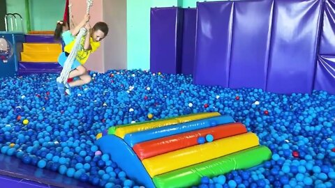 Sofia and a lot of colored balls on the Playground for kids