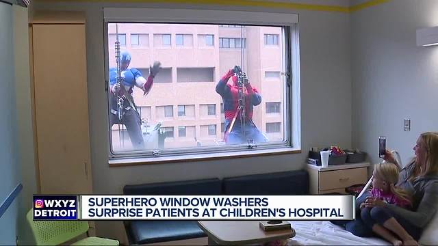 Superheroes washing windows surprise kids at Children's Hospital of Michigan