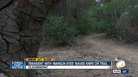 Transient with "manson eyes" waves knife on trail