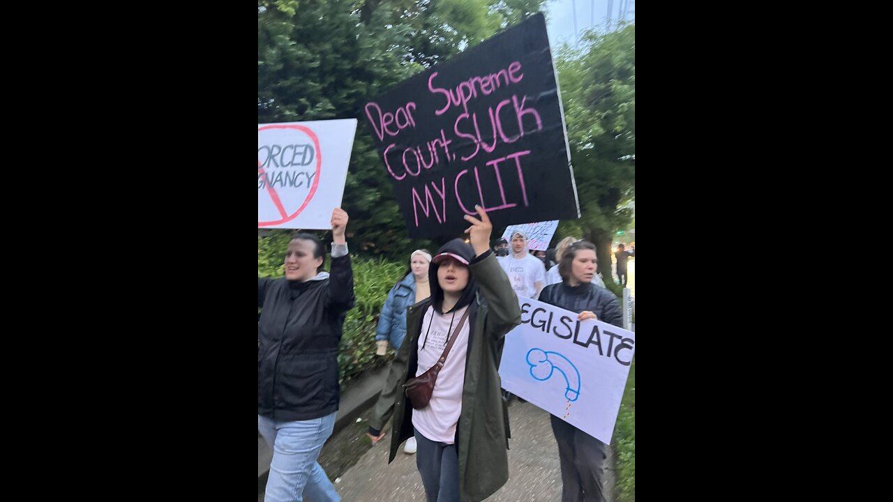 Protestors carrying signs as they march to the justices’ houses.