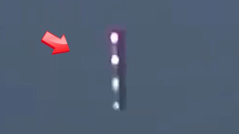 Stick-shaped UFO floating in the sky above shimmering in the reflection of the sun
