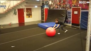 Giovane pratica incredibili acrobazie con una palla da ginnastica