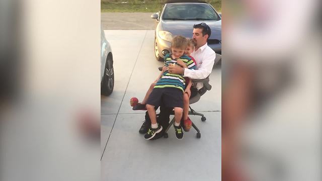 Kids Having Fun With Their Dad Riding An Office Chair