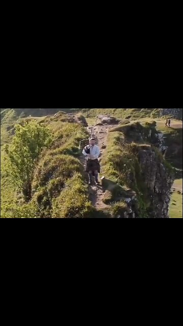 Morning Bagpipes On The Edge of a Cliff In The Scottish Highlands - HaloRockNews