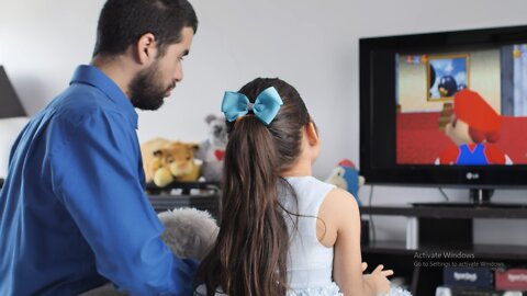 Little girl playing video games with her father