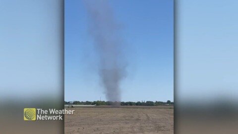 Towering dust devil spins across Quebec field