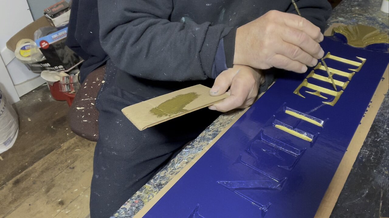 Painting the lettering on a custom carved Cape cod Quarterboard