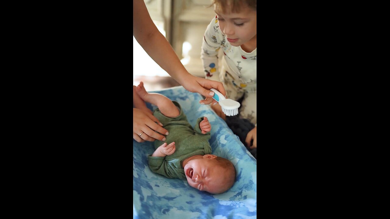 Boy Helping her Mother to Brush the Baby's Hair