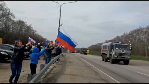 People of Voronezh cheer for the Russian military as they pass