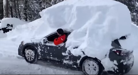 Guy has a lot of snow on car.