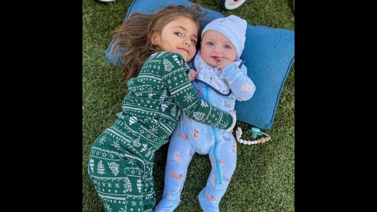 girl laughing with her 7-month-old brother