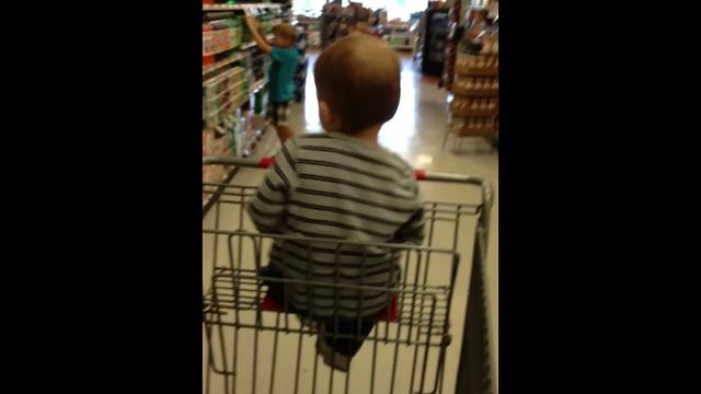 "Tot Boy Dances In A Shopping Cart In A Store"