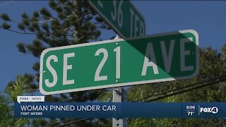 Woman pinned under car