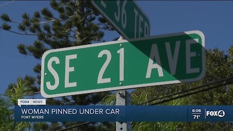 Woman pinned under car