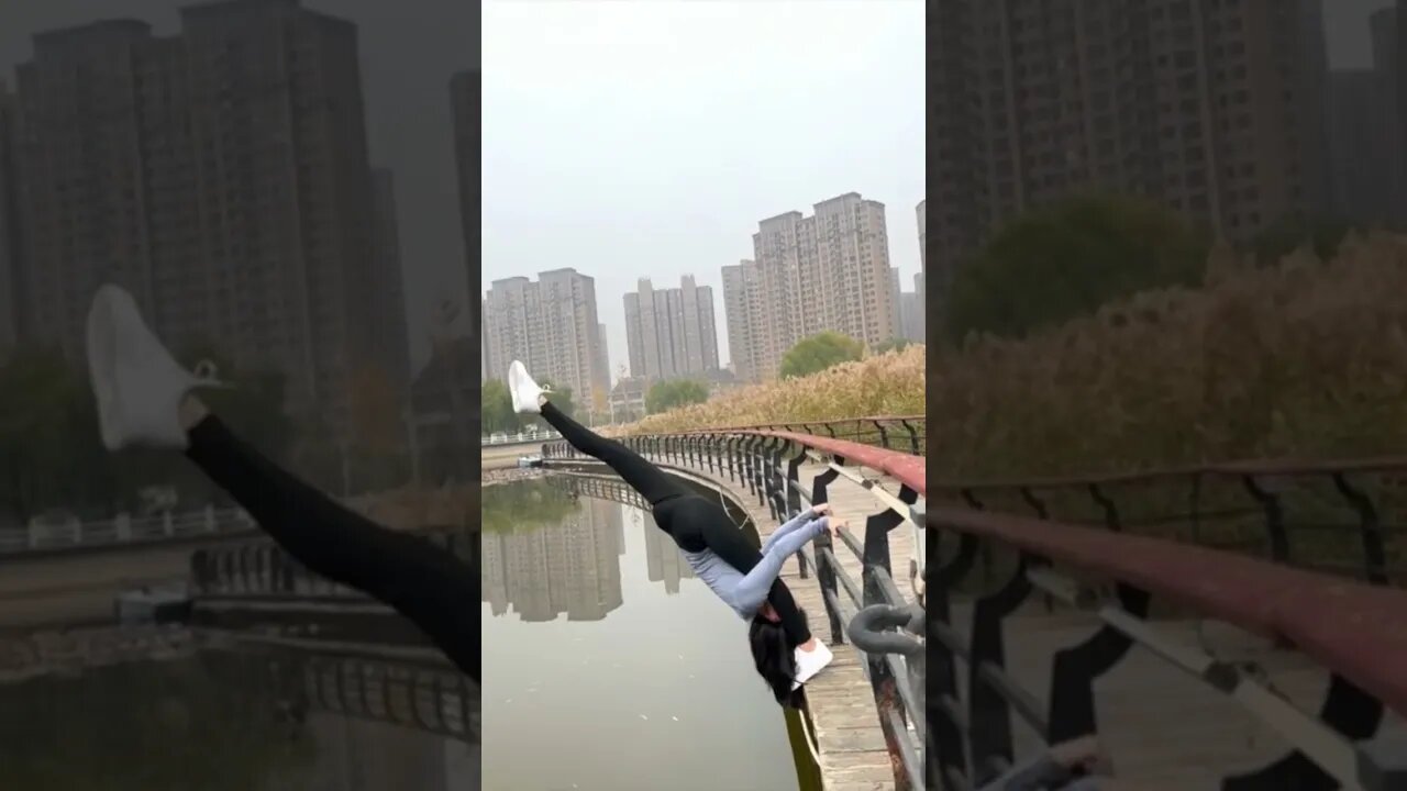 Tall Lean Chinese Girl Gives Gymnastic Demonstration Hanging Over A Lake