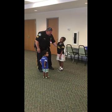 Little girl traveling the country hugging police