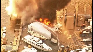 Boat owner watches anxiously as nearby yacht burns