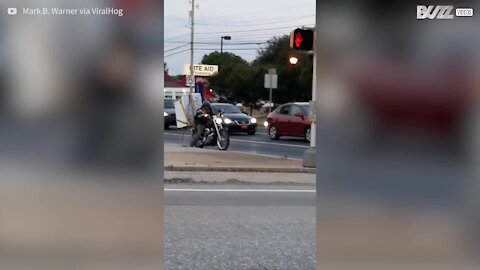 Homem transporta máquina de lavar numa moto